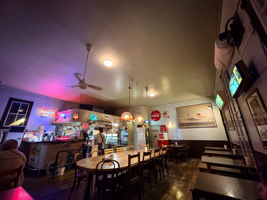 The cozy interior of a retro diner with wooden tables, vintage posters on the walls, and warm lighting.