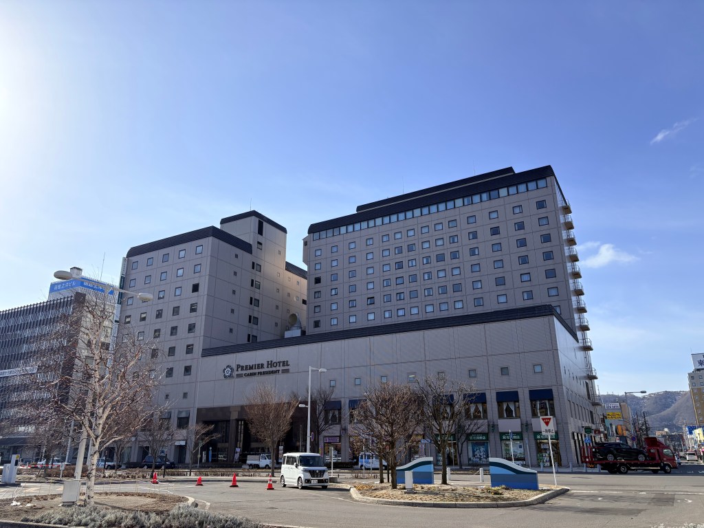 Exterior view of the tall Premier Hotel -CABIN- Hakodate building under a blue sky.