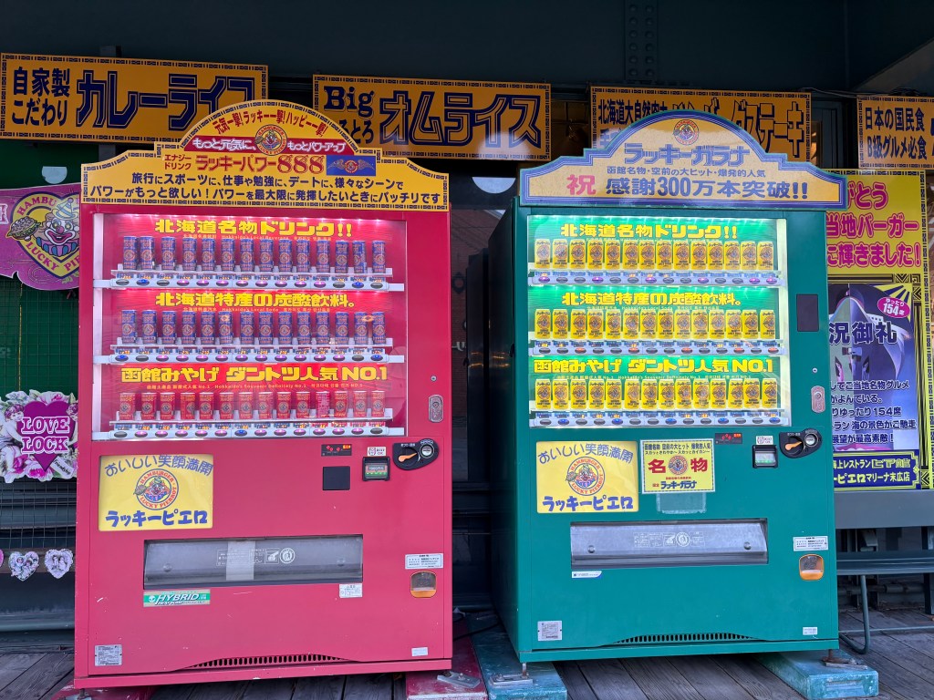 A vibrant red and green vending machine stocked with Lucky Gara soda and energy drinks.
