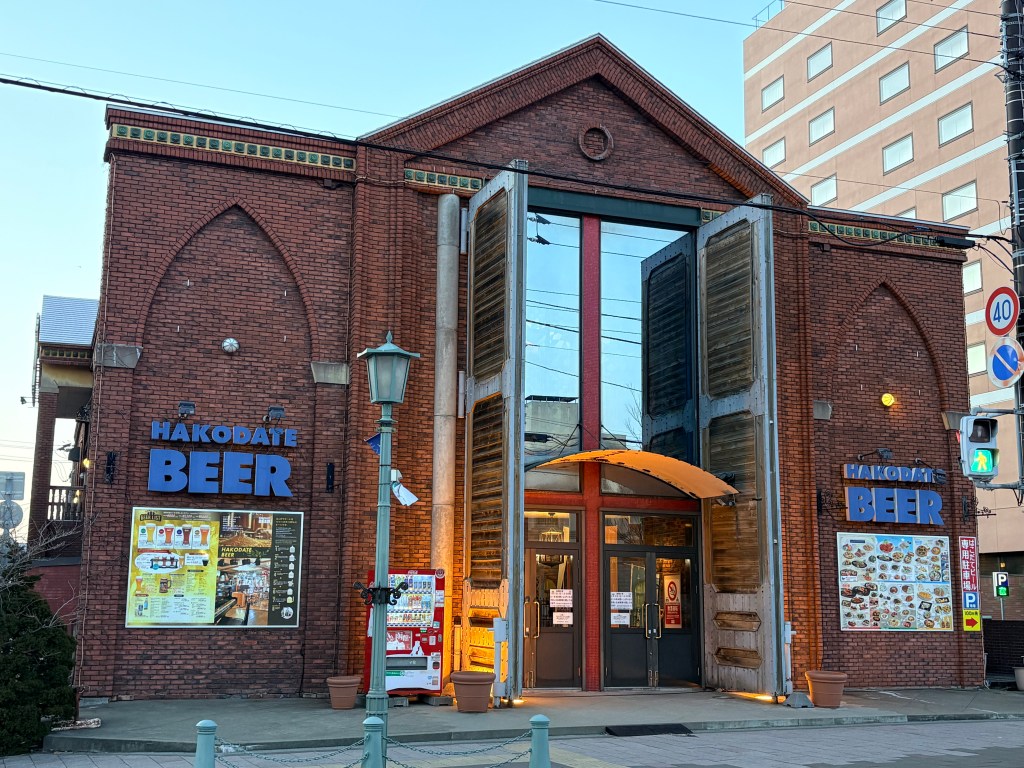 The grand red-brick exterior of the Hakodate Beer hall, a historic building in the bay area.
