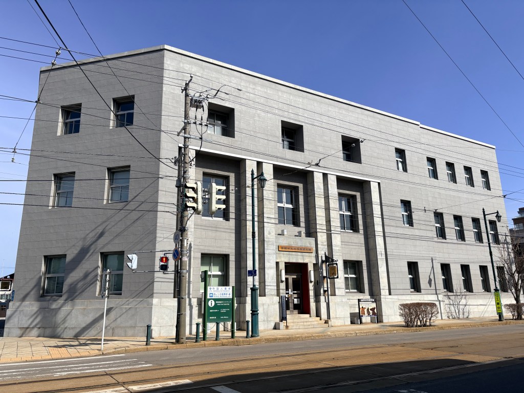 Exterior of a grand three-story stone building under a blue sky.