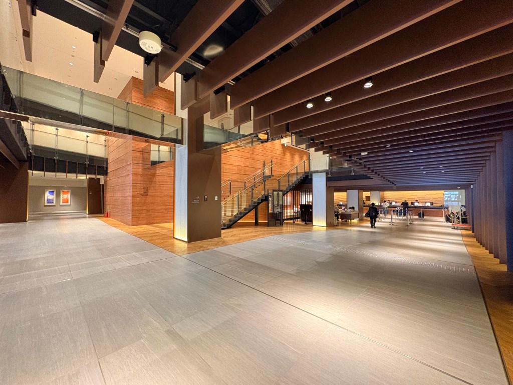 Wide-angle view of the expansive lobby and high ceiling at Hakodate Kokusai Hotel, looking toward the reception desk and staircase.